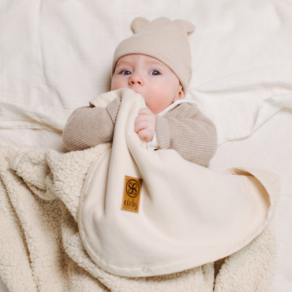 baby med hvid teddy tæppe